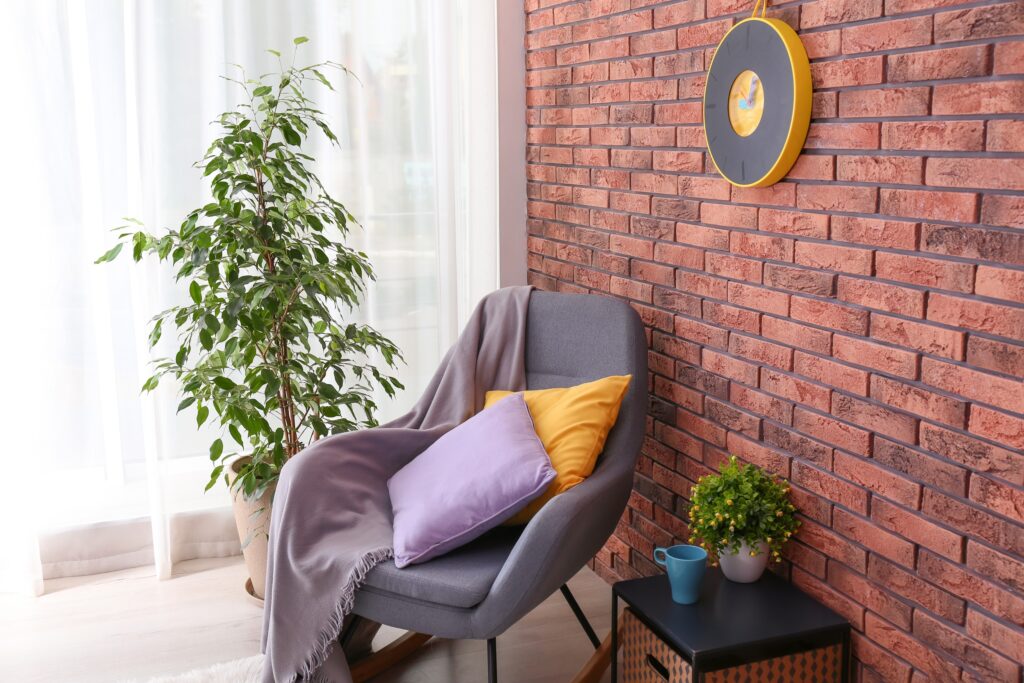 Stylish room interior with armchair and potted ficus - JLM Masonry & Waterproofing